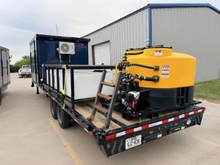Air Base drone trailer with enclosed front compartment, mini-split AC, and a large yellow tank on the flatbed