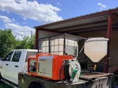 Spray skid with tank, inductor cone, generator and hose reel on a flatbed pickup