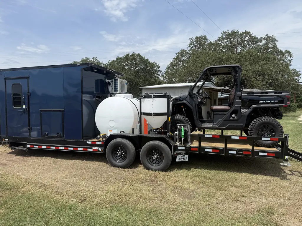 Custom navy drone spray trailer with mixing tank, chemical inductor, hose reel and a UTV on the deck